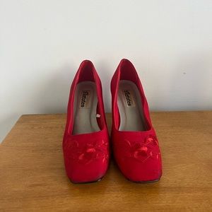 Super cute red heels with embroidered flowers on them